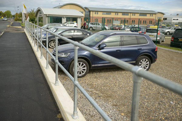 key clamps shown made into a railing with carpark behind