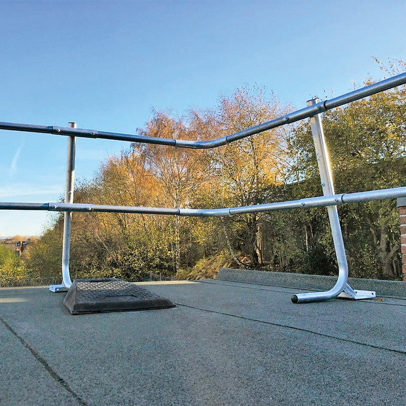 close up view of roof edge protection handrails in corner of a roof with trees in background