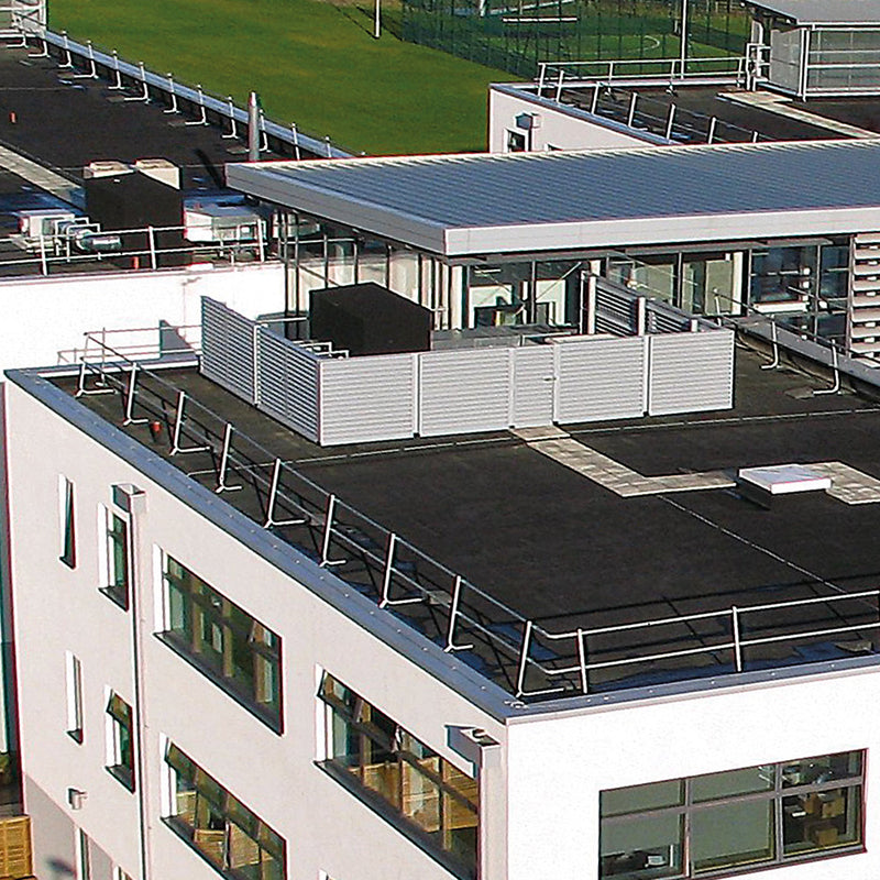 view of a rooftop from a distance showing roof guard rails on side of multiple buildings.